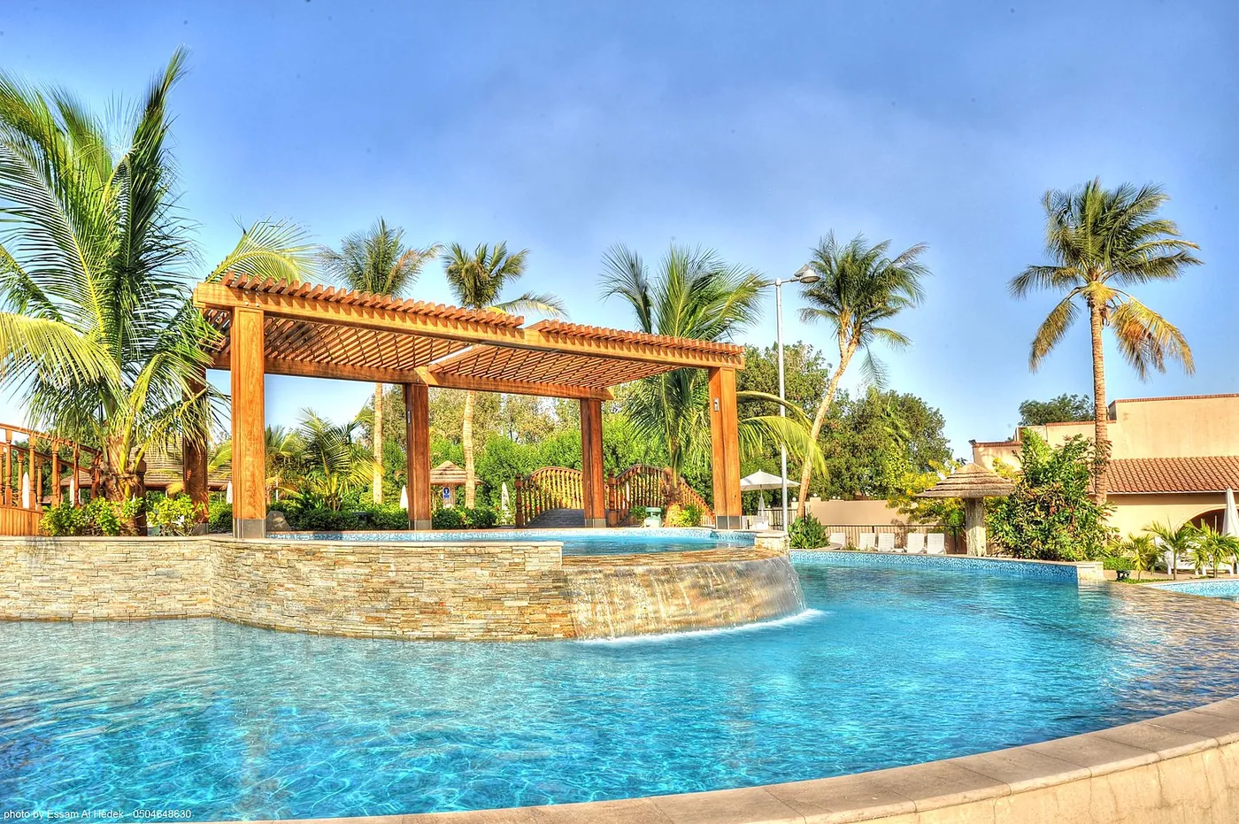 Poolside pergola and waterfall feature