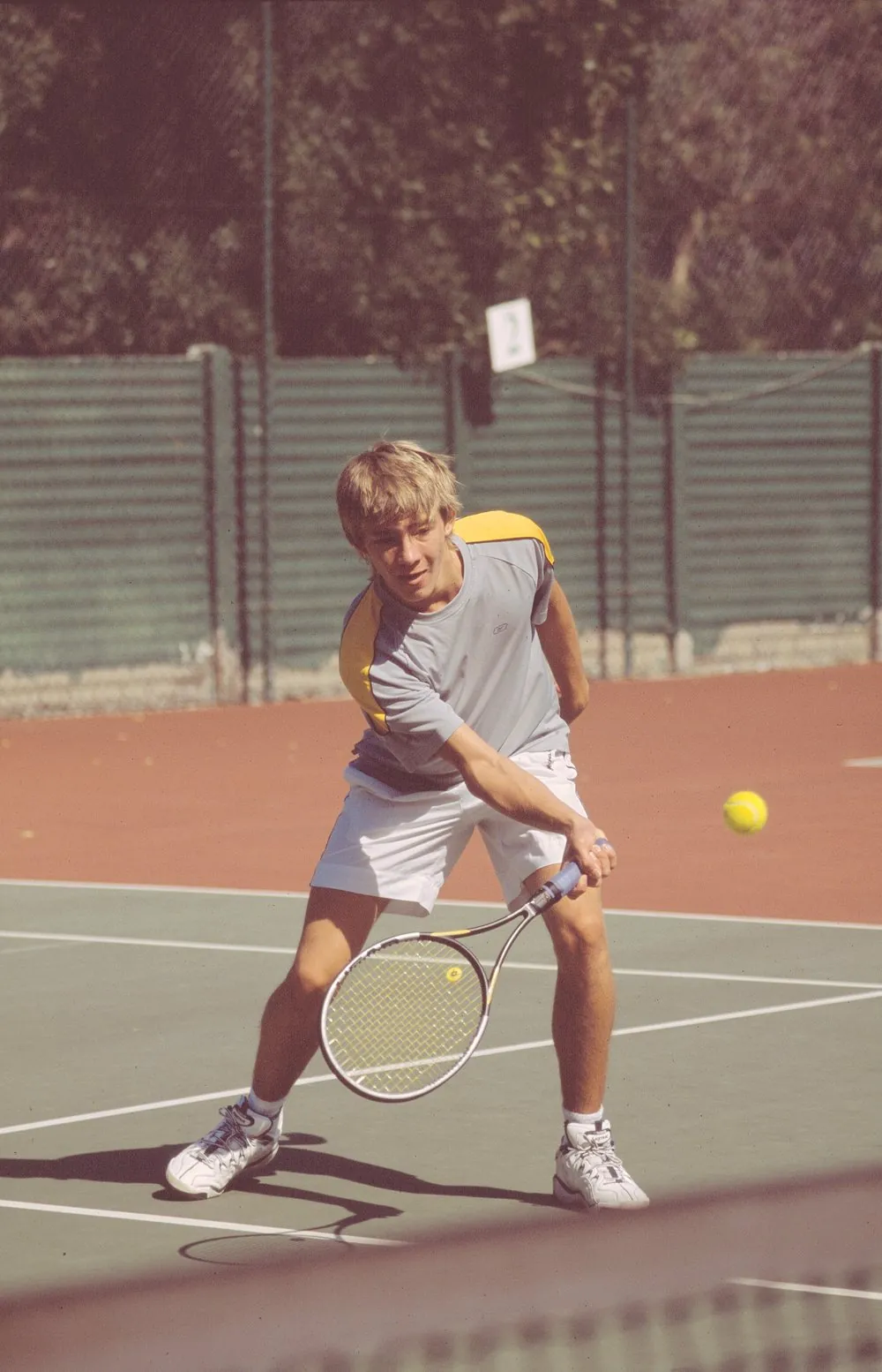 A young resident playing tennis on the community courts